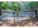 Single-story home boasts an attached garage and a stone chimney, blending seamlessly with the natural surroundings at 4116 Wendell Way, Snellville, GA 30039