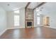 Bright living room features wood floors, vaulted ceiling with beam, and stone fireplace at 4116 Wendell Way, Snellville, GA 30039