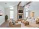 Inviting living room features a stone fireplace, comfortable seating, and a view to a plant and the outside at 4116 Wendell Way, Snellville, GA 30039