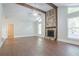 Bright living room with a stone fireplace, wooden beams, and a large window showcasing the natural light at 4116 Wendell Way, Snellville, GA 30039