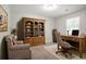 Cozy home office furnished with a desk, shelves, chair and a comfortable armchair for relaxing or reading at 4116 Wendell Way, Snellville, GA 30039