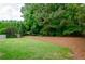 Large backyard featuring mature trees and grassy lawn at 2535 Castlerock Ct, Cumming, GA 30041