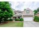 Charming two-story brick home boasts a well-manicured lawn, attached two-car garage, and inviting curb appeal at 2535 Castlerock Ct, Cumming, GA 30041