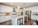 Modern kitchen features a large island with seating, stainless steel appliances, and white cabinetry at 2535 Castlerock Ct, Cumming, GA 30041