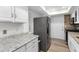 Functional kitchen equipped with white cabinets, stainless steel refrigerator, and granite counters for a clean, modern look at 6851 Roswell Rd # L1, Atlanta, GA 30328