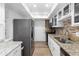 Well-lit kitchen showcasing granite countertops, stainless steel appliances, and mosaic backsplash for a modern touch at 6851 Roswell Rd # L1, Atlanta, GA 30328
