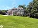 A large two-story brick home boasts a deck, a manicured lawn, and mature trees at 1292 Hidden Spirit Trl, Lawrenceville, GA 30045