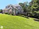 Large, well-maintained backyard showcasing a two-story brick home with a spacious deck and lush landscaping at 1292 Hidden Spirit Trl, Lawrenceville, GA 30045