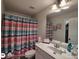 Bathroom featuring a single sink vanity and tub/shower with colorful striped curtain at 1292 Hidden Spirit Trl, Lawrenceville, GA 30045
