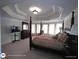 Spacious bedroom boasts a four-poster bed, sitting area, and large windows, offering natural light and comfort at 1292 Hidden Spirit Trl, Lawrenceville, GA 30045