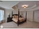 Primary bedroom with a tray ceiling, a four poster bed, and carpeted floors at 1292 Hidden Spirit Trl, Lawrenceville, GA 30045