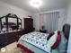 Bedroom featuring a bed with a decorative quilt and dark wood furniture at 1292 Hidden Spirit Trl, Lawrenceville, GA 30045