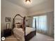 Well-lit bedroom featuring a stylish four-poster bed, providing a calm and inviting space at 1292 Hidden Spirit Trl, Lawrenceville, GA 30045