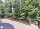 Wooden deck with brown railings overlooking a verdant backyard with lush trees and greenery at 1292 Hidden Spirit Trl, Lawrenceville, GA 30045