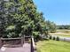 Wood deck overlooks a beautifully landscaped backyard with mature trees, green grass, and a picturesque view at 1292 Hidden Spirit Trl, Lawrenceville, GA 30045
