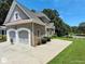 Side view of the house showing the two-car garage, driveway, and well-maintained lawn at 1292 Hidden Spirit Trl, Lawrenceville, GA 30045