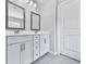 Bathroom featuring double sinks, decorative mirrors, tile floors and white cabinets at 212 Torch Dr, Acworth, GA 30102