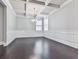 Bright dining room featuring beautiful hardwood floors, wainscoting, coffered ceilings, and a modern chandelier at 212 Torch Dr, Acworth, GA 30102