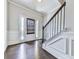 Elegant foyer with dark hardwood floors, white trim, and a staircase with black metal railing at 212 Torch Dr, Acworth, GA 30102
