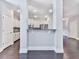 Open-concept kitchen with white cabinetry, stainless steel appliances, and a breakfast bar overlooking the living area at 212 Torch Dr, Acworth, GA 30102