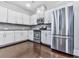 Modern kitchen featuring white cabinets, stainless steel appliances, granite countertops, and dark hardwood floors at 212 Torch Dr, Acworth, GA 30102