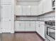Well-lit kitchen with white cabinets, stainless steel oven and microwave, and a tiled backsplash at 212 Torch Dr, Acworth, GA 30102