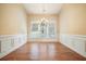 Bright dining room showcases hardwood floors, elegant wainscoting, and an ornate chandelier over three windows at 620 Willow Haven Way, Suwanee, GA 30024