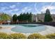 Community pool with fence, shaded seating, and lush green trees and grass at 620 Willow Haven Way, Suwanee, GA 30024