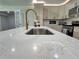 Kitchen with a large island, white countertops and backsplash, and gold fixtures at 6751 Davidson Ct, Lithonia, GA 30058