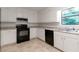 Clean kitchen with white cabinets, black appliances, and light countertops at 1240 Rocky Rd, Lawrenceville, GA 30044