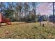 Picture of a big backyard with mature trees and shrubs, wood deck, and a clear sky, perfect for outdoor activities at 4185 Duesenberg Dr, Tucker, GA 30084