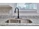 Up close shot of the updated sink with granite countertops and neutral backsplash at 4185 Duesenberg Dr, Tucker, GA 30084