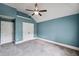 Spacious bedroom painted in a light blue tone with carpeted floors, ceiling fan and two doors at 4465 Saint Andrews Crest Dr, Cumming, GA 30040