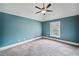 Cozy bedroom painted in a light blue tone with carpeted floors, ceiling fan, and a bright window at 4465 Saint Andrews Crest Dr, Cumming, GA 30040