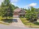 Charming brick home with a well-manicured lawn, mature trees, and attached two-car garage at 4465 Saint Andrews Crest Dr, Cumming, GA 30040