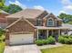 Charming two-story brick home featuring an attached garage, covered porch, and manicured landscaping at 4465 Saint Andrews Crest Dr, Cumming, GA 30040