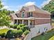 Brick home with a manicured lawn, a side-entry garage, and mature landscaping on a sunny day at 4465 Saint Andrews Crest Dr, Cumming, GA 30040