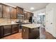 Modern kitchen with dark cabinetry, granite countertops, stainless steel appliances, and an island with breakfast bar at 4465 Saint Andrews Crest Dr, Cumming, GA 30040