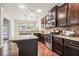 Spacious kitchen features an island, granite counters, dark cabinetry, stainless appliances, and great lighting at 4465 Saint Andrews Crest Dr, Cumming, GA 30040