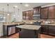 Beautiful kitchen offering stainless steel appliances, dark cabinets, granite counters and center island at 4465 Saint Andrews Crest Dr, Cumming, GA 30040