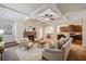 Inviting living room with stone fireplace, coffered ceiling, and arched doorways to the kitchen and dining area at 4465 Saint Andrews Crest Dr, Cumming, GA 30040