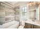 Bright bathroom featuring a tub-shower combo with tile surround, vanity, and natural light at 504 E Howard Ave, Decatur, GA 30030