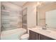 Beautiful bathroom featuring a tub with tile surround, modern vanity, and great lighting at 504 E Howard Ave, Decatur, GA 30030