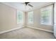 This bedroom features three windows, carpet flooring, and a ceiling fan at 504 E Howard Ave, Decatur, GA 30030