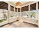 Bright sunroom featuring hardwood floors, large windows with custom blinds, and contemporary light fixture at 504 E Howard Ave, Decatur, GA 30030
