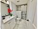 Clean bathroom with marble floors, white vanity, and shower and red flower at 5347 Ocarol Ct, Stone Mountain, GA 30088