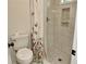 Bathroom featuring a white toilet and marble tiled walk-in shower with built-in shelving at 5347 Ocarol Ct, Stone Mountain, GA 30088