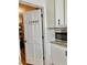 Pantry door and appliances in kitchen with white cabinets and subway tile backsplash at 5347 Ocarol Ct, Stone Mountain, GA 30088