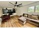 Comfortable living room with a modern ceiling fan, couch and built-in shelving next to a window at 5347 Ocarol Ct, Stone Mountain, GA 30088