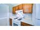 Fully equipped kitchen with white stove, vent and upper cabinets by the refrigerator at 2161 Denson Sw Ln, Marietta, GA 30008